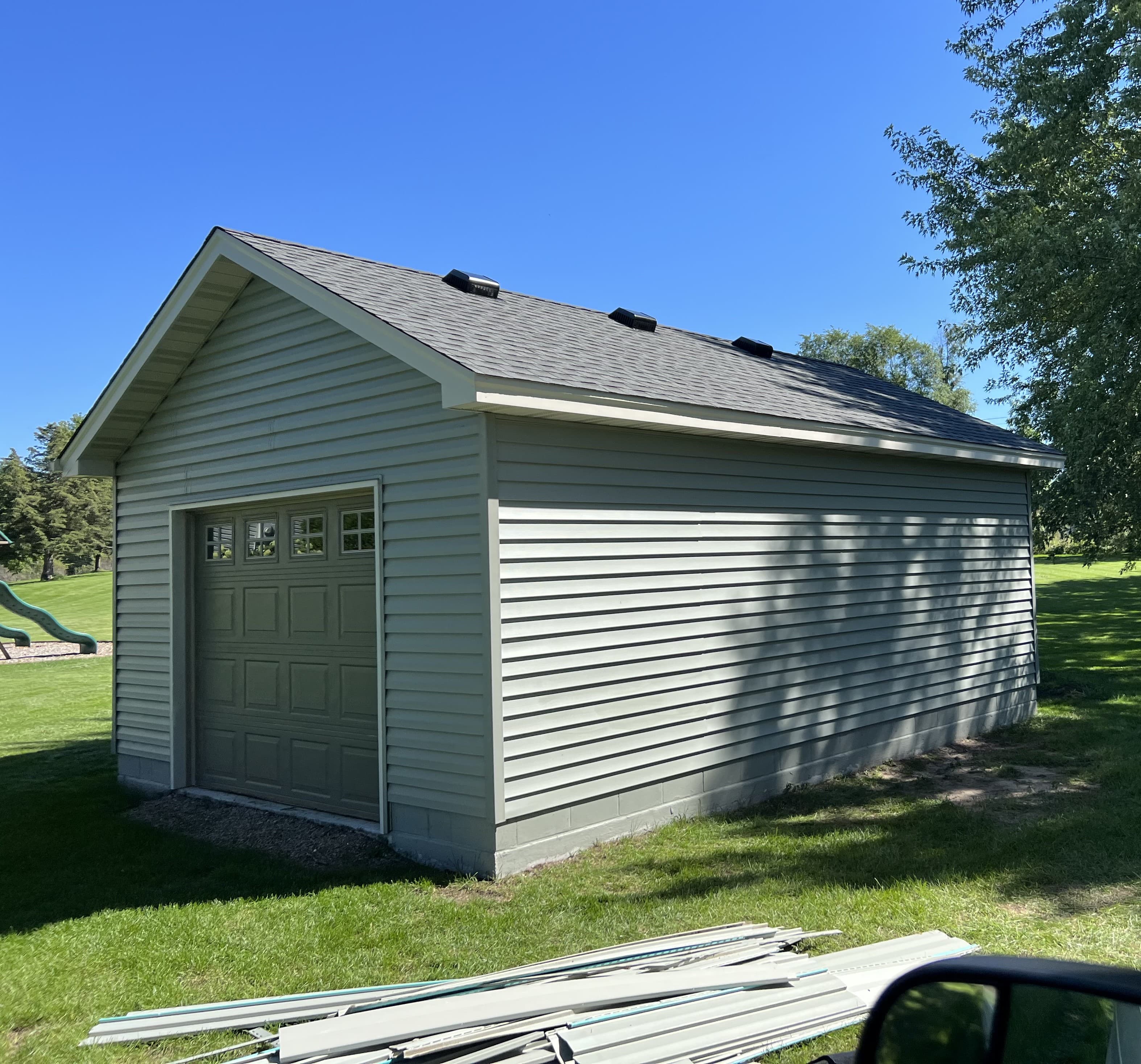 Brand new single detached garage with gray vynil siding 